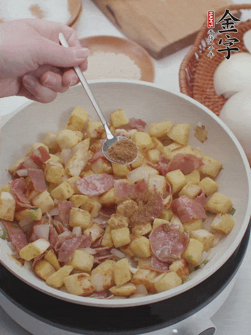 起锅少油，煸香洋葱丁、葱白，加入BB贝博艾弗森
培根火腿翻炒几下，再加入馒头丁、1小勺孜然粉、少许盐翻炒均匀并铺平。